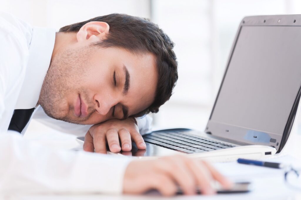 Tired person, who suffers from sleep apnea, sleeping at work.