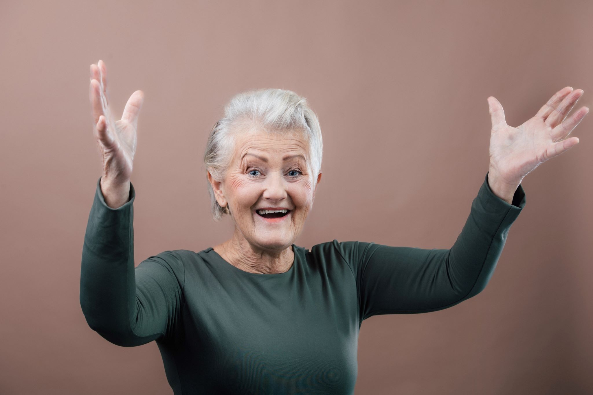 portrait of smiling senior woman with raised arms